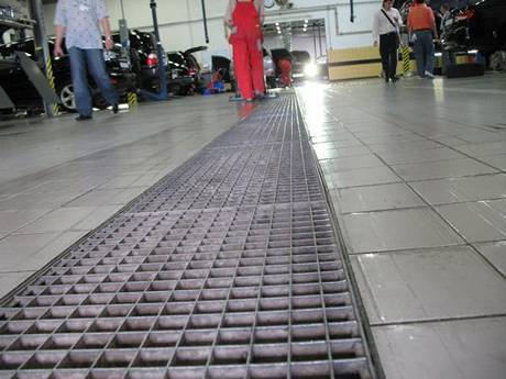 This is floor of car wash with steel grating gully cover.