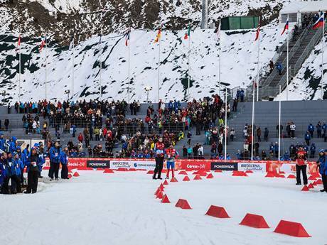 Some people are racing in the middle of the venue, surrounded by many people standing on the stairs to watch.