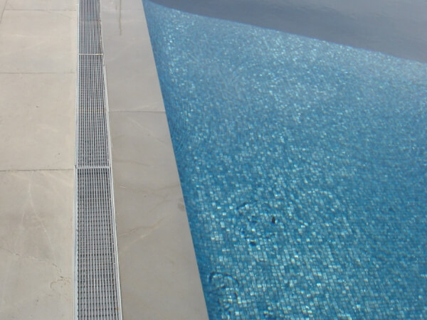 The polished stainless steel 304 wedge wire grates are installed around the swimming pool.